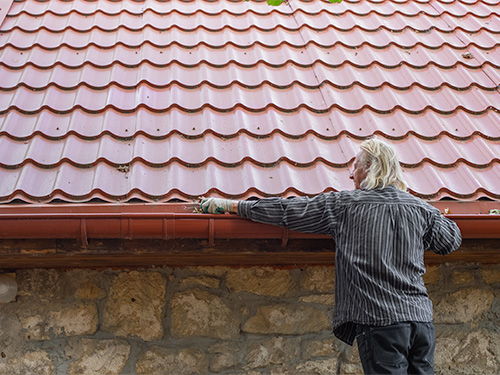 Homeowner cleaning gutters.